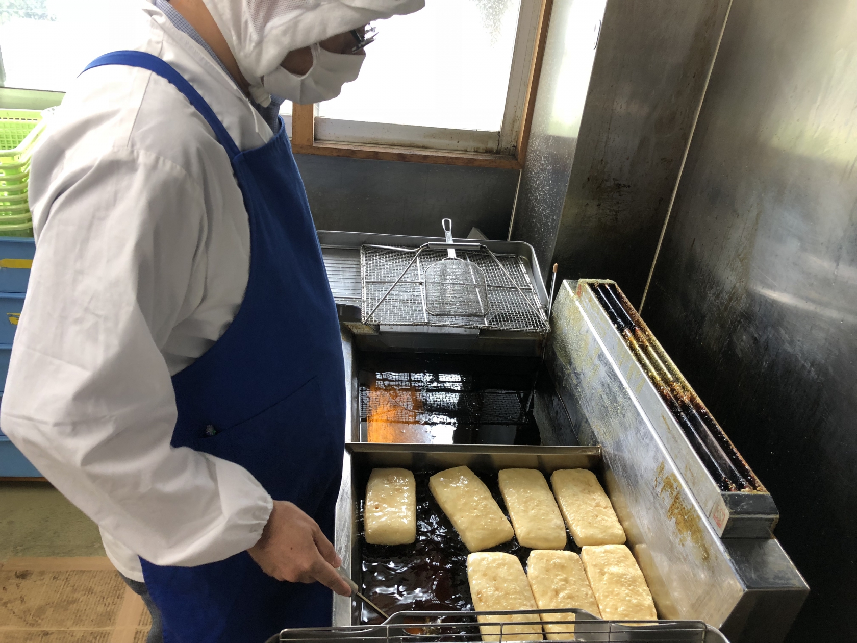 豆腐を揚げる利用者さん