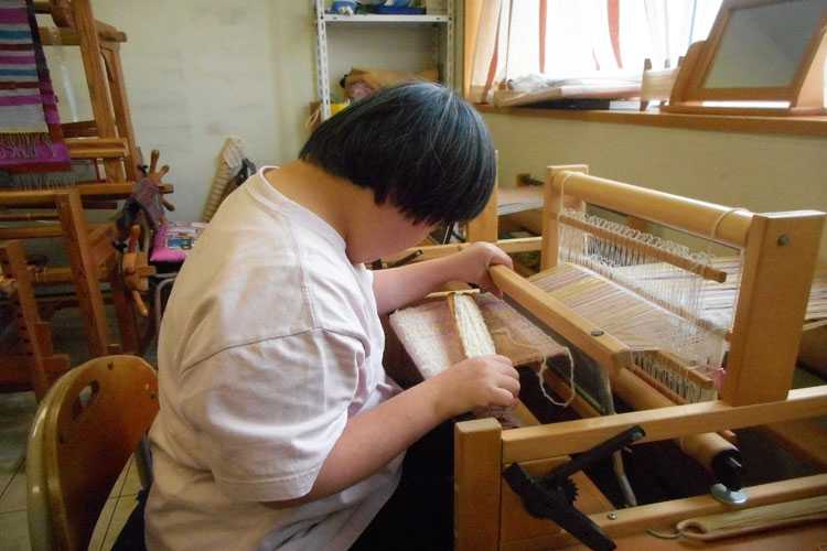 機織り作業をする利用者さんの写真