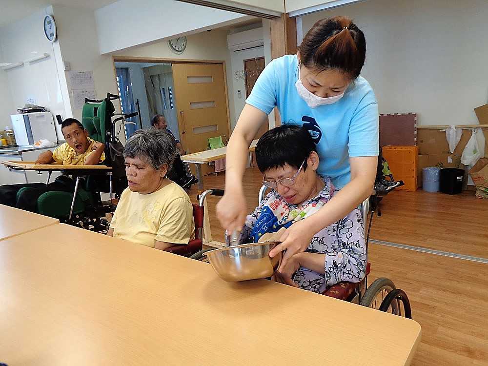 ホットケーキの生地を職員と混ぜる