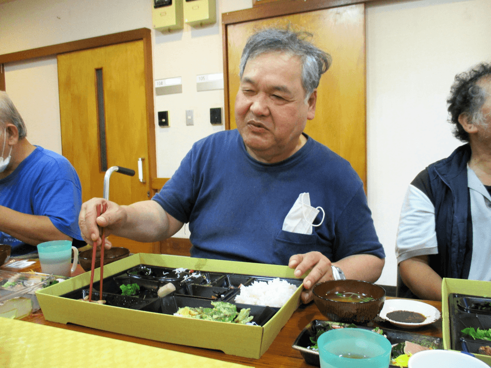 お弁当に箸を延ばしています